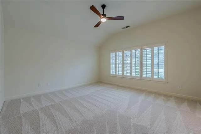 a backyard of a house with large trees and plants