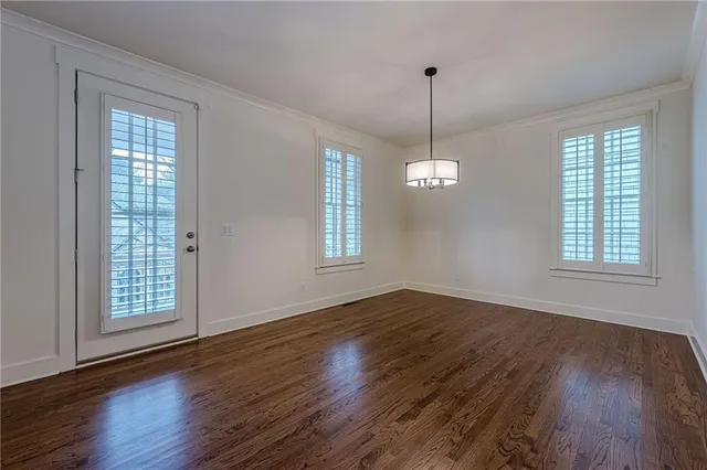 a large kitchen with granite countertop a stove a sink a center island and wooden floor