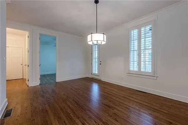 a kitchen with kitchen island granite countertop wooden floors white cabinets and stainless steel appliances