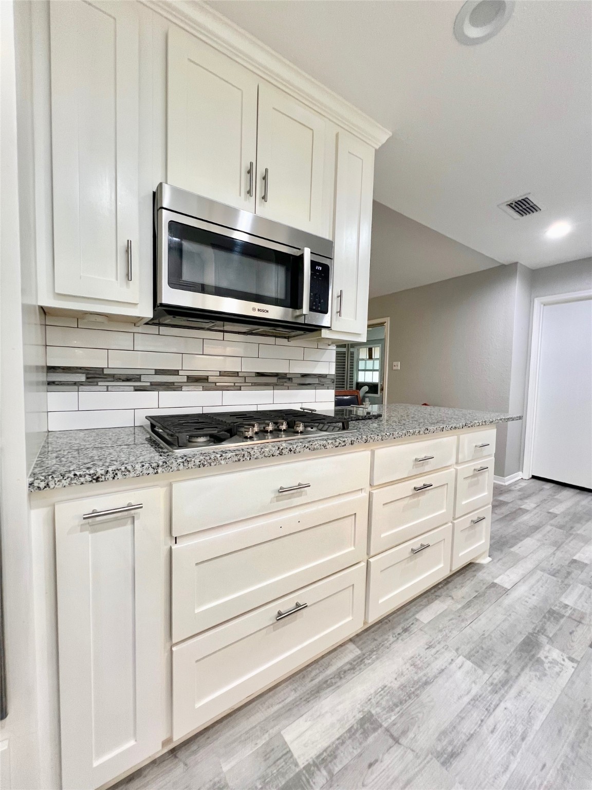 2101 Roland Rue Street Pearland, TX 77581 - Photo 6 of 12 a kitchen with granite countertop white cabinets and stainless steel appliances