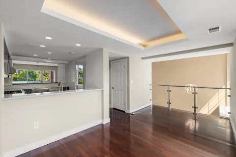 a view of a kitchen with wooden floor and a window
