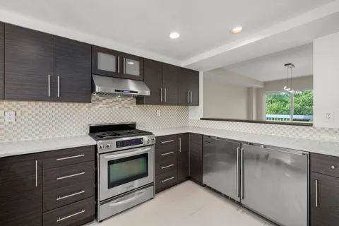 a kitchen with granite countertop wooden cabinets and stainless steel appliances