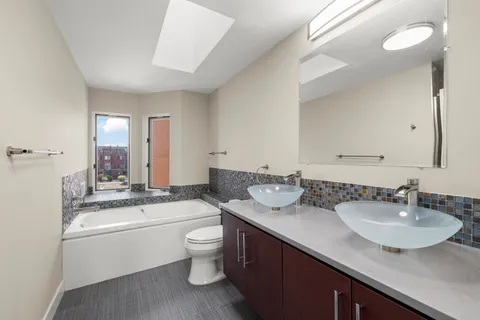 a bathroom with a granite countertop sink double vanity and a mirror