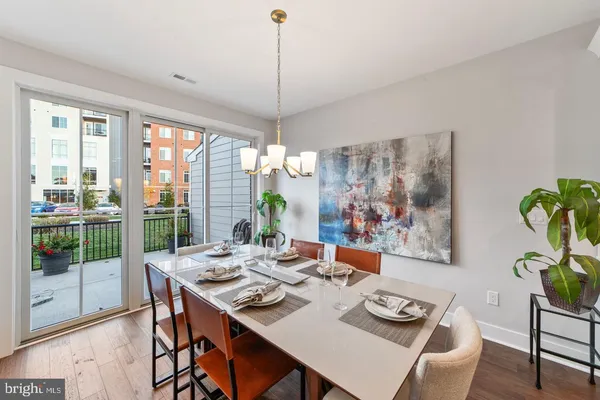 a dining room with furniture a kitchen and a chandelier