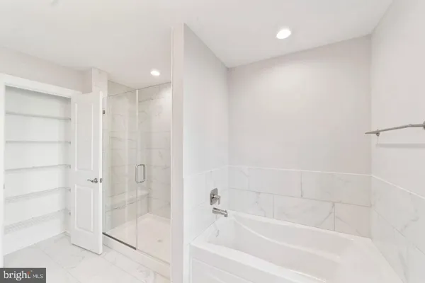 a bathroom with a sink tub shower and a mirror