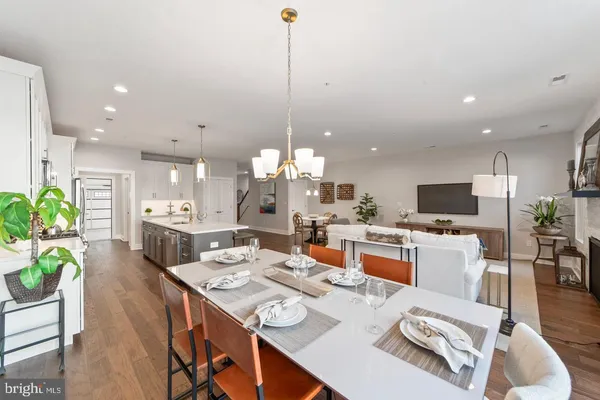 a living room with furniture a flat screen tv and a dining table