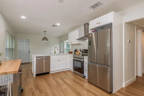 a kitchen with stainless steel appliances granite countertop a refrigerator and a stove top oven