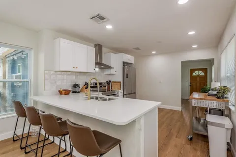 a kitchen with a sink cabinets and wooden floor