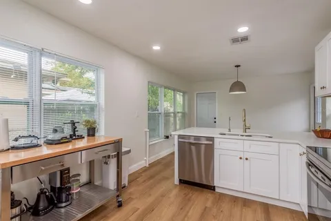 a large white kitchen with a large window