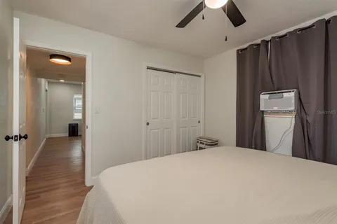 a bedroom with a bed and wooden floor