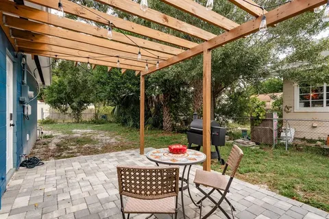a view of a patio with a table chairs and a backyard