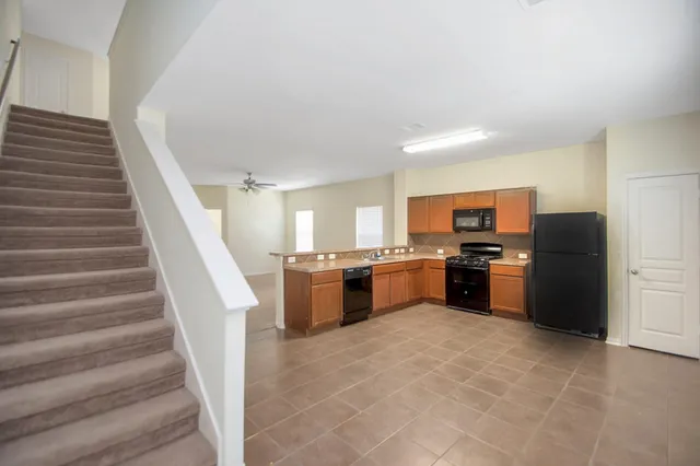 a kitchen with stainless steel appliances kitchen island granite countertop a refrigerator and a sink