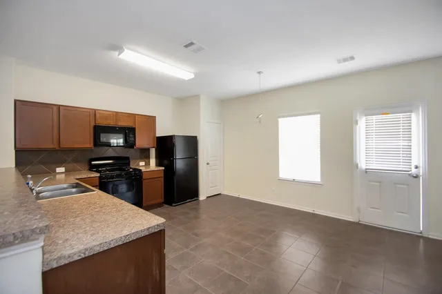 a kitchen with granite countertop a stove and a sink