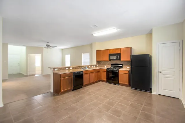 a large kitchen with a stove a refrigerator and a kitchen island