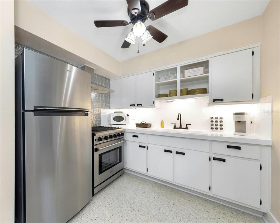 116 Read Street Tarpon Springs, FL 34689 - Photo 27 of 49 a kitchen with white cabinets and stainless steel appliances