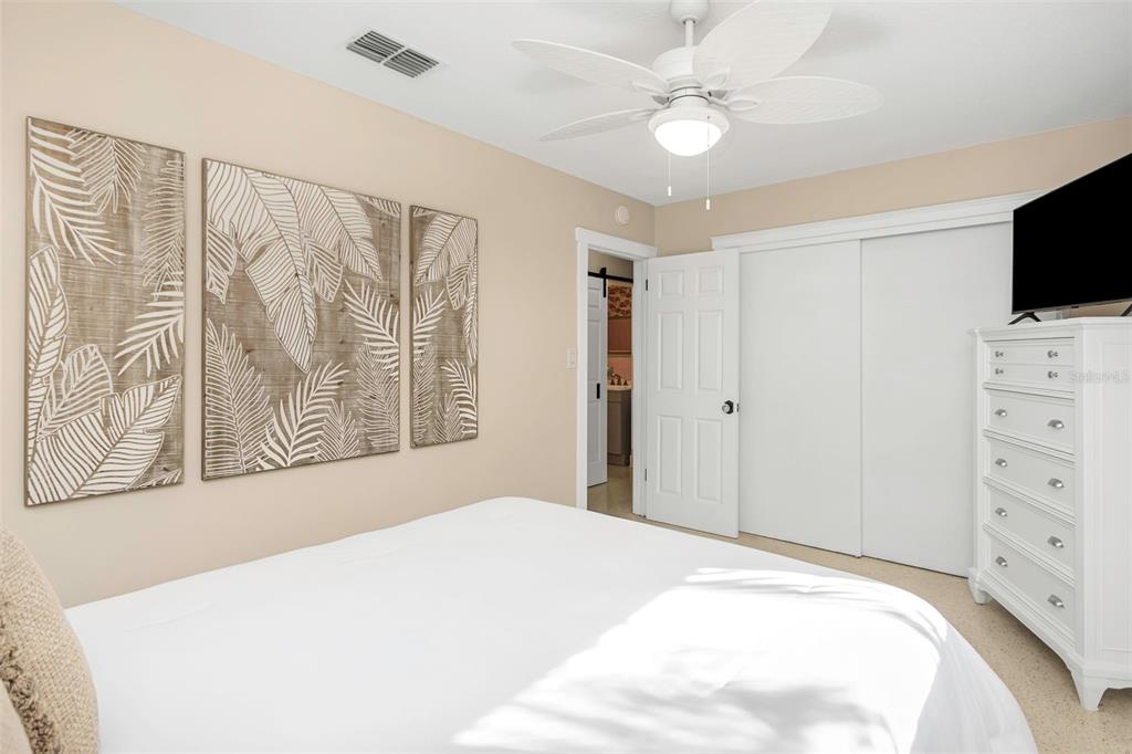 116 Read Street Tarpon Springs, FL 34689 - Photo 40 of 49 a bedroom with a large bed and a flat tv screen on dresser