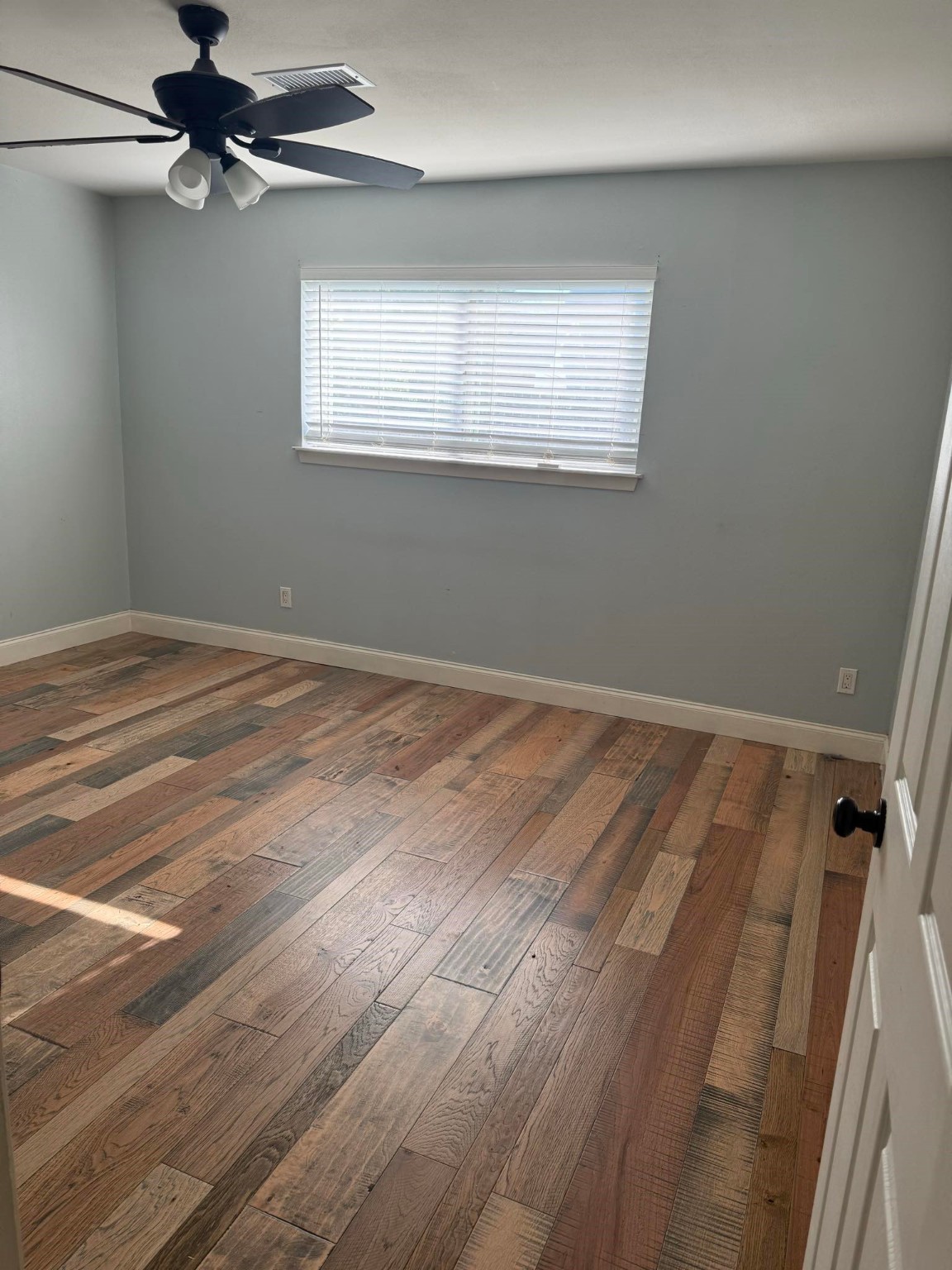 11210 Sageoak Drive Houston, TX 77089 - Photo 14 of 18 en empty room with wooden floor fan and windows