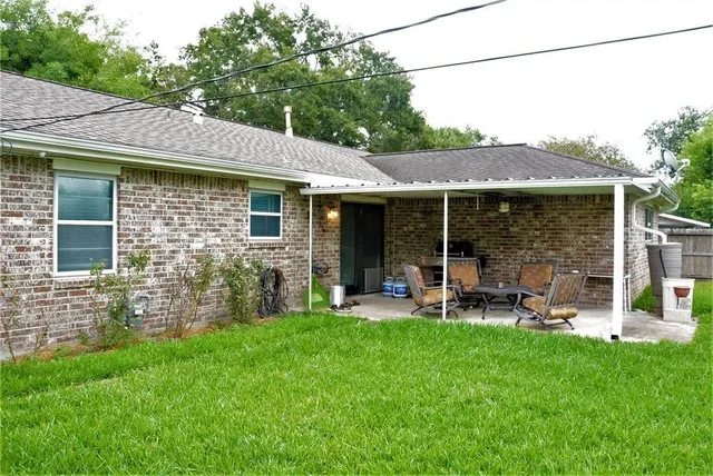 a view of a chair and table in backyard of the house