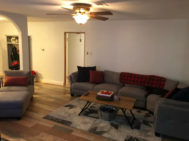 a living room with furniture and a wooden floor