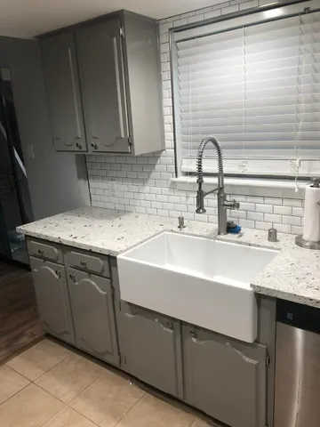 a sink with granite countertop cabinets
