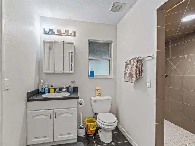 a bathroom with a toilet sink vanity and mirror