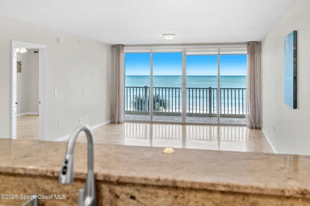 a kitchen with stainless steel appliances granite countertop a sink a stove a refrigerator cabinets and a dining table