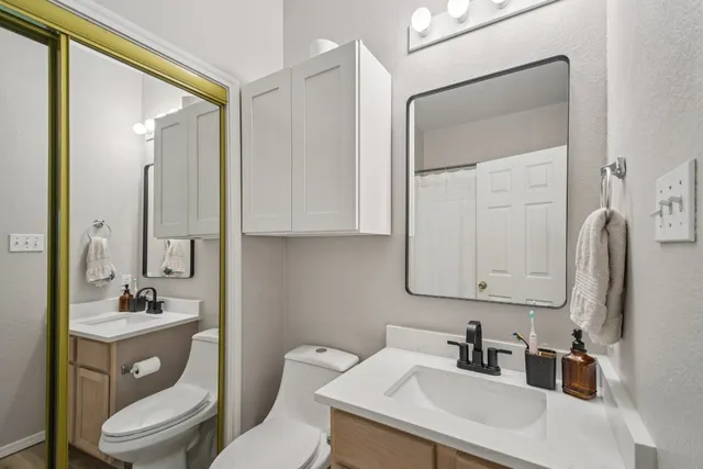 a bathroom with a toilet sink a mirror and shower