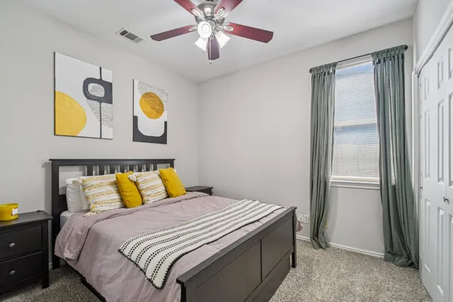 a bedroom with a bed and painting on the wall