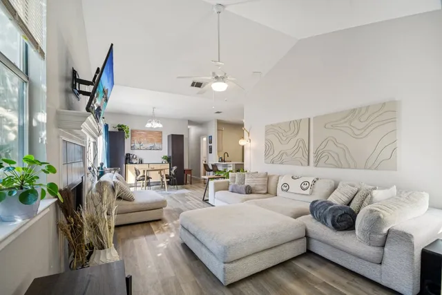 a living room with furniture ceiling fan and a potted plant