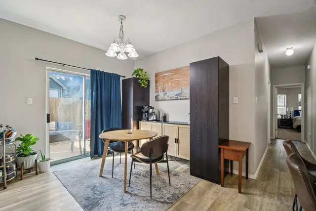 a dining room with furniture a chandelier and wooden floor