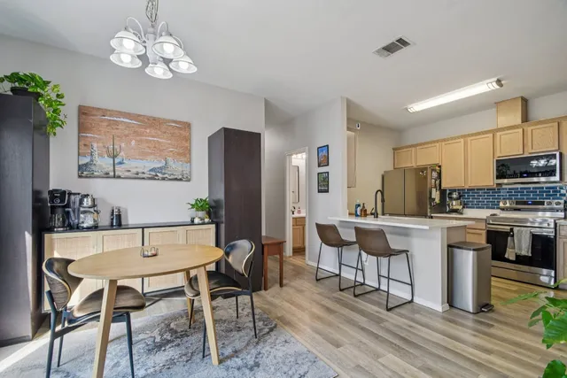 a view of a dining room with furniture a chandelier and wooden floor