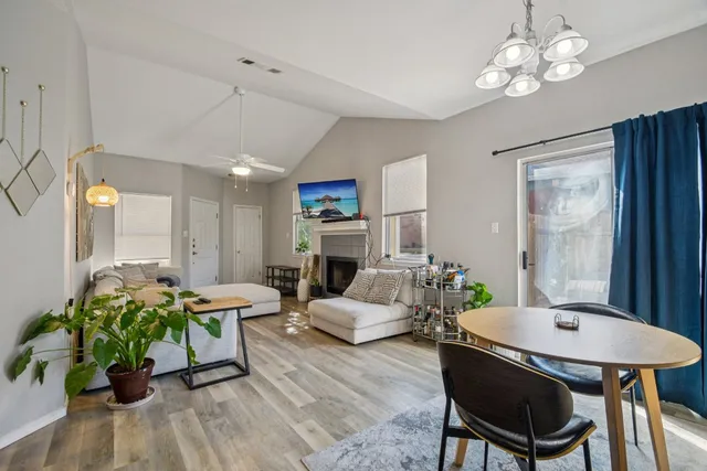 a living room with furniture a chandelier and a dining table