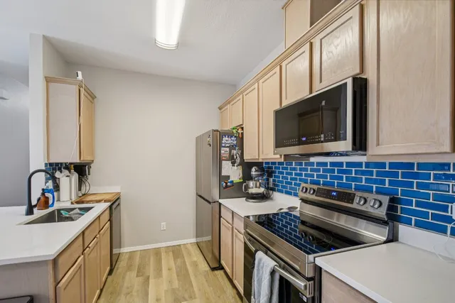 a kitchen that has a sink and a stove top oven