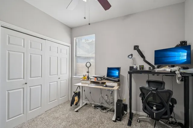 a view of a workspace with furniture and a window