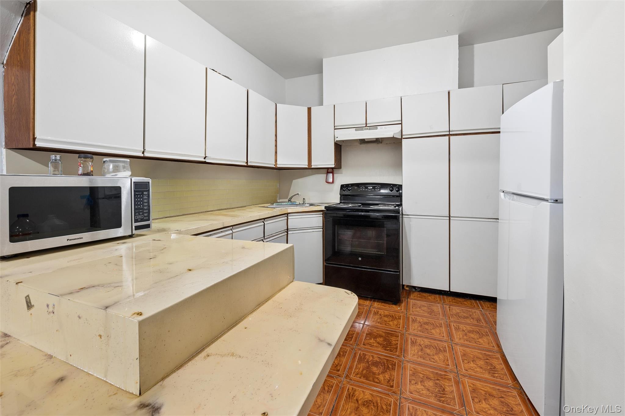 976 Sacket Avenue Bronx, NY 10462 - Photo 7 of 20 a kitchen with granite countertop cabinets and steel stainless steel appliances