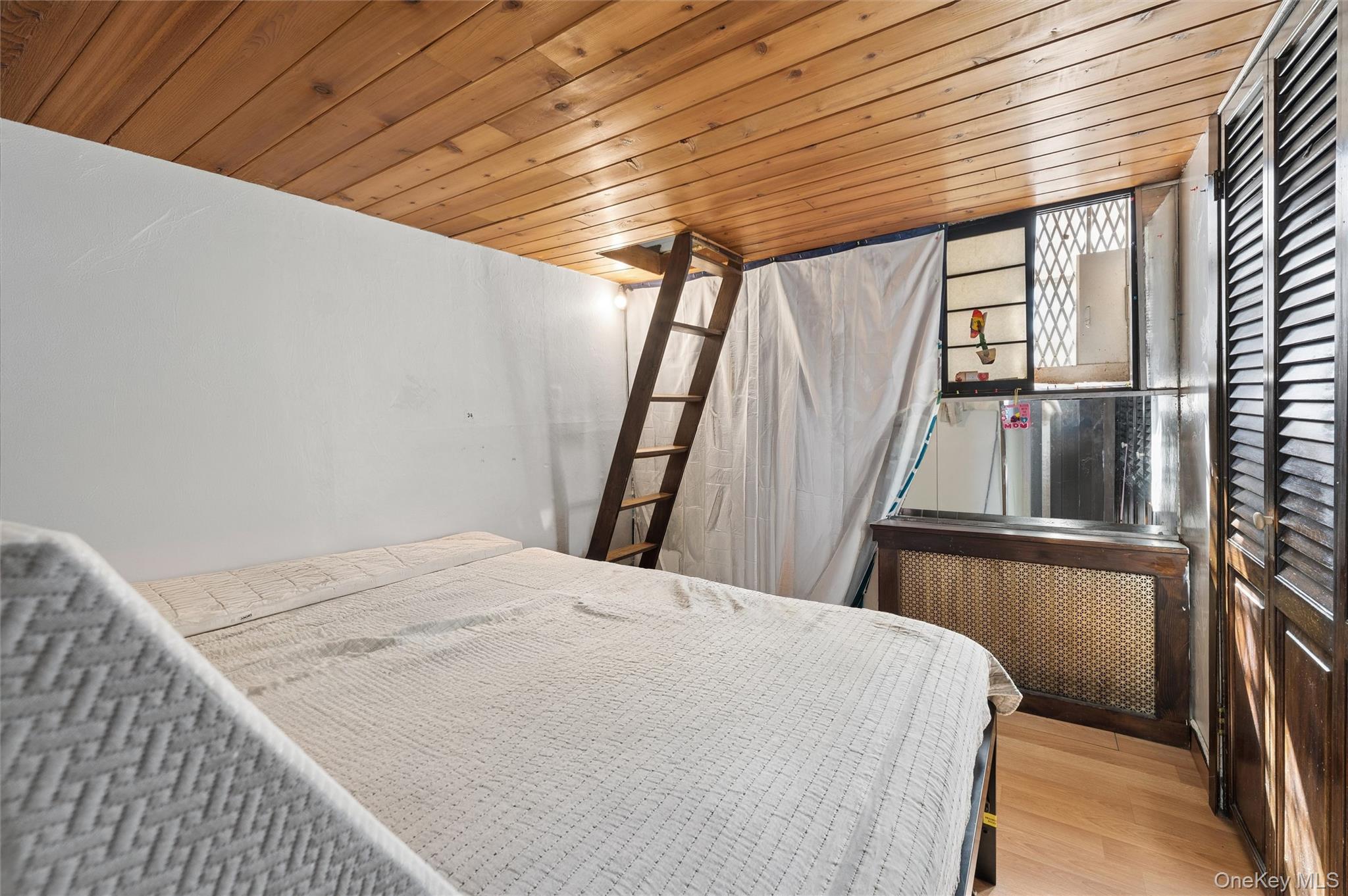 976 Sacket Avenue Bronx, NY 10462 - Photo 9 of 20 a bed sitting in a bedroom next to a window