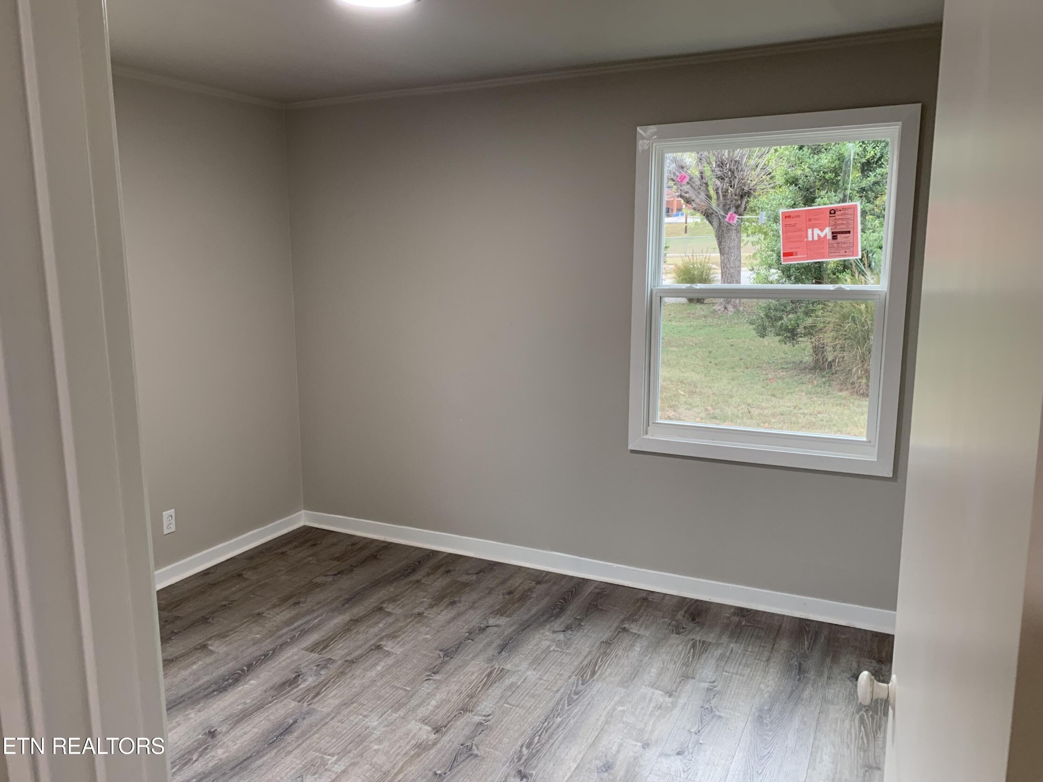 102 Audubon Road Oak Ridge, TN 37830 - Photo 9 of 19 an empty room with wooden floor and windows