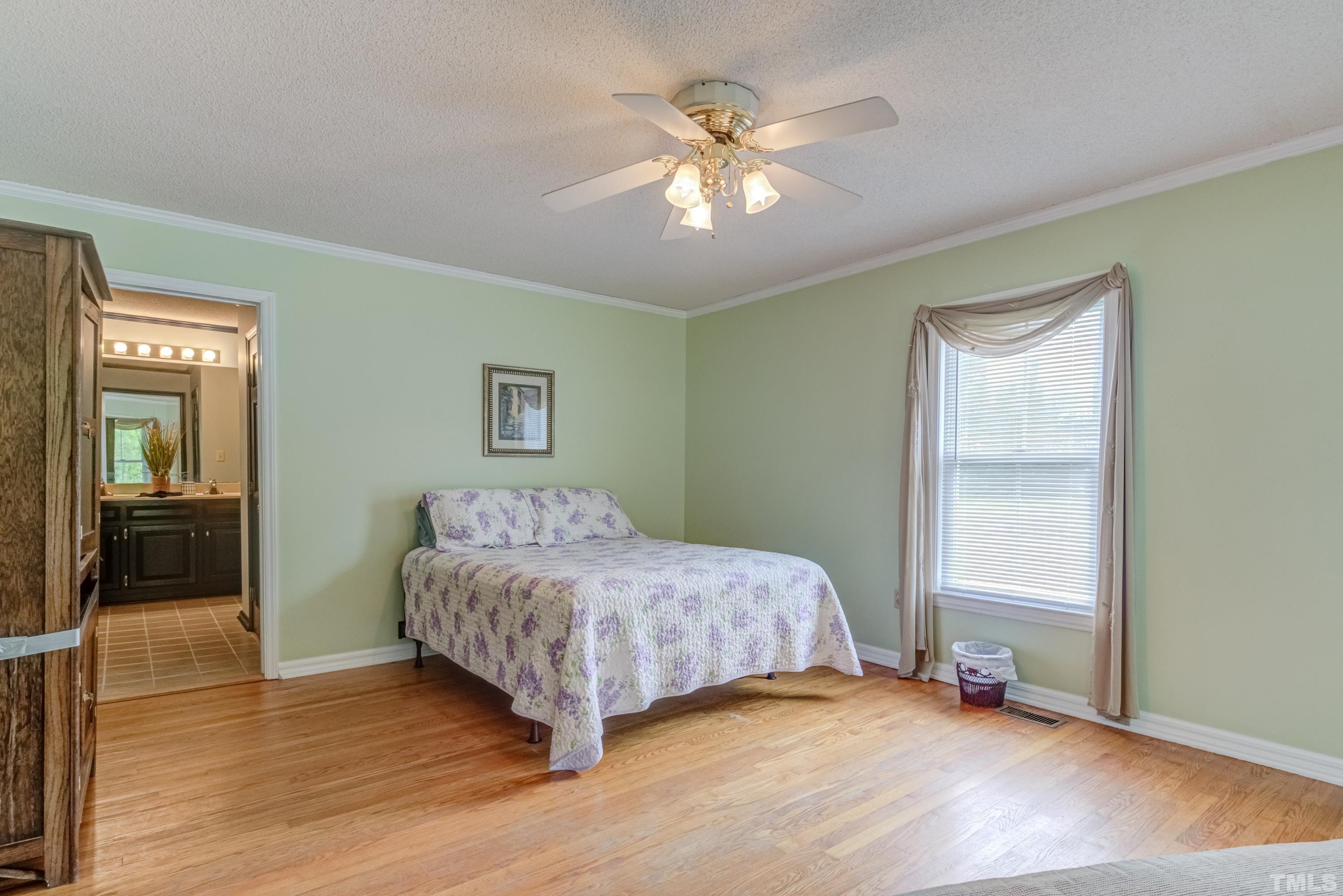 8837 Ransdell Road Raleigh, NC 27603 - Photo 23 of 48 a bedroom with a bed and a chandelier