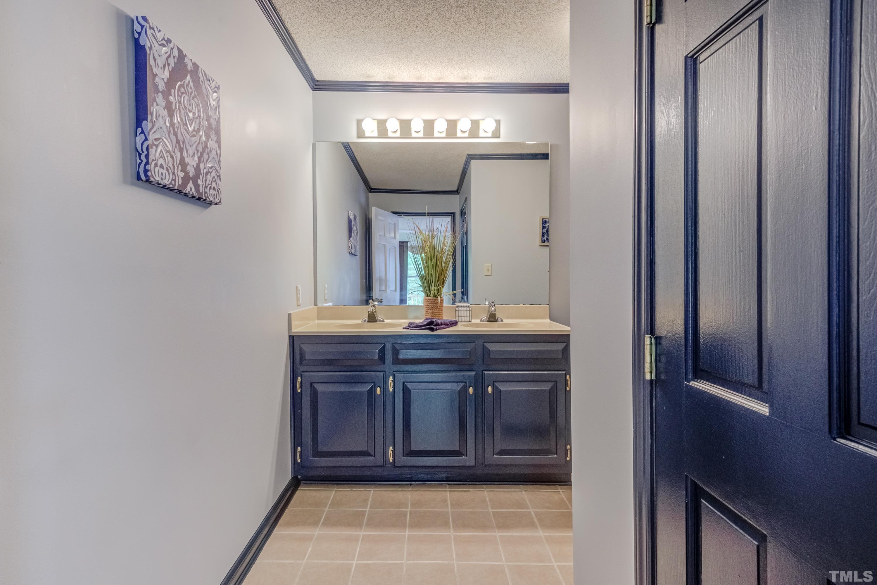 8837 Ransdell Road Raleigh, NC 27603 - Photo 26 of 48 a bathroom with a double vanity sink and a mirror