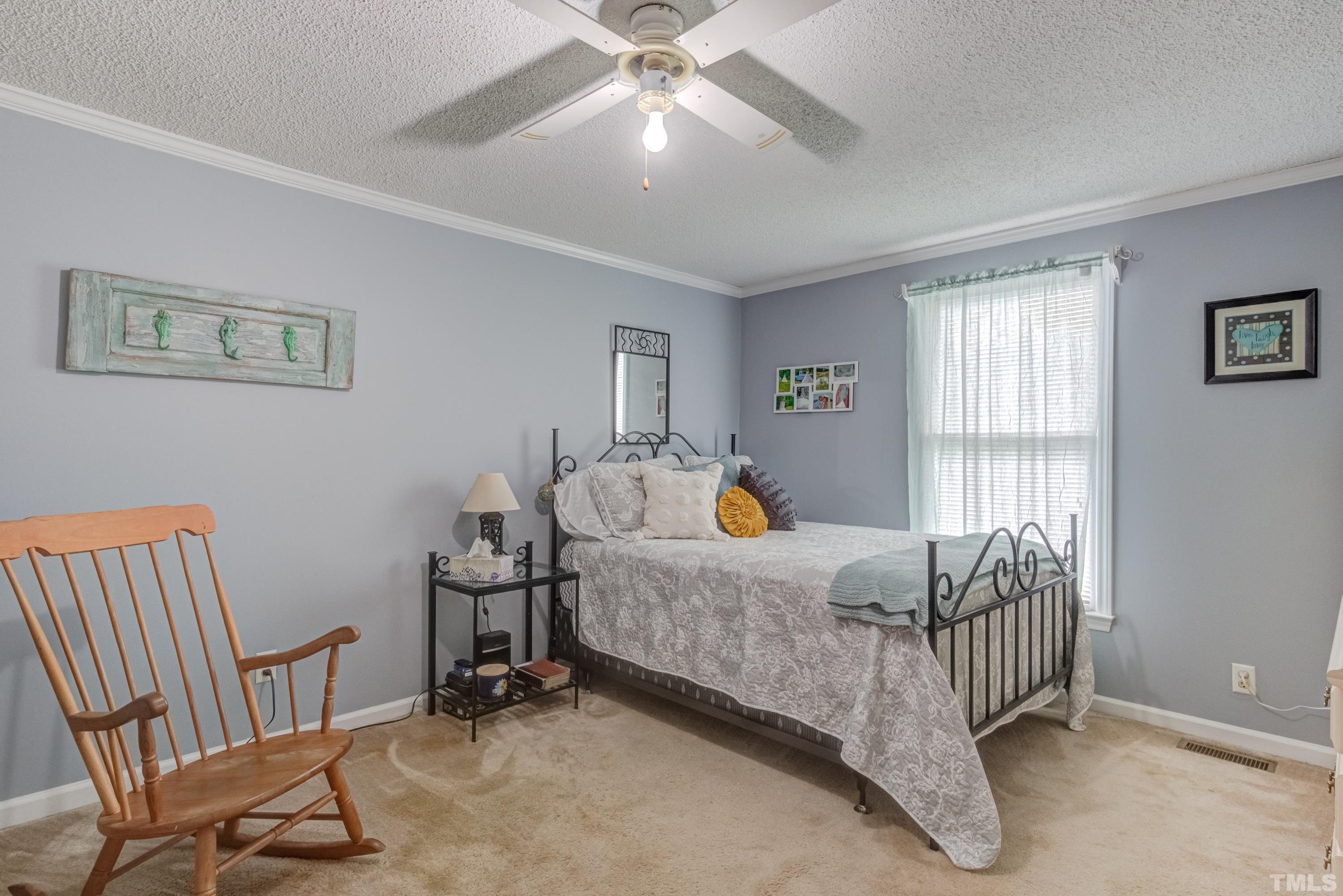 8837 Ransdell Road Raleigh, NC 27603 - Photo 33 of 48 a bedroom with a bed and a chandelier