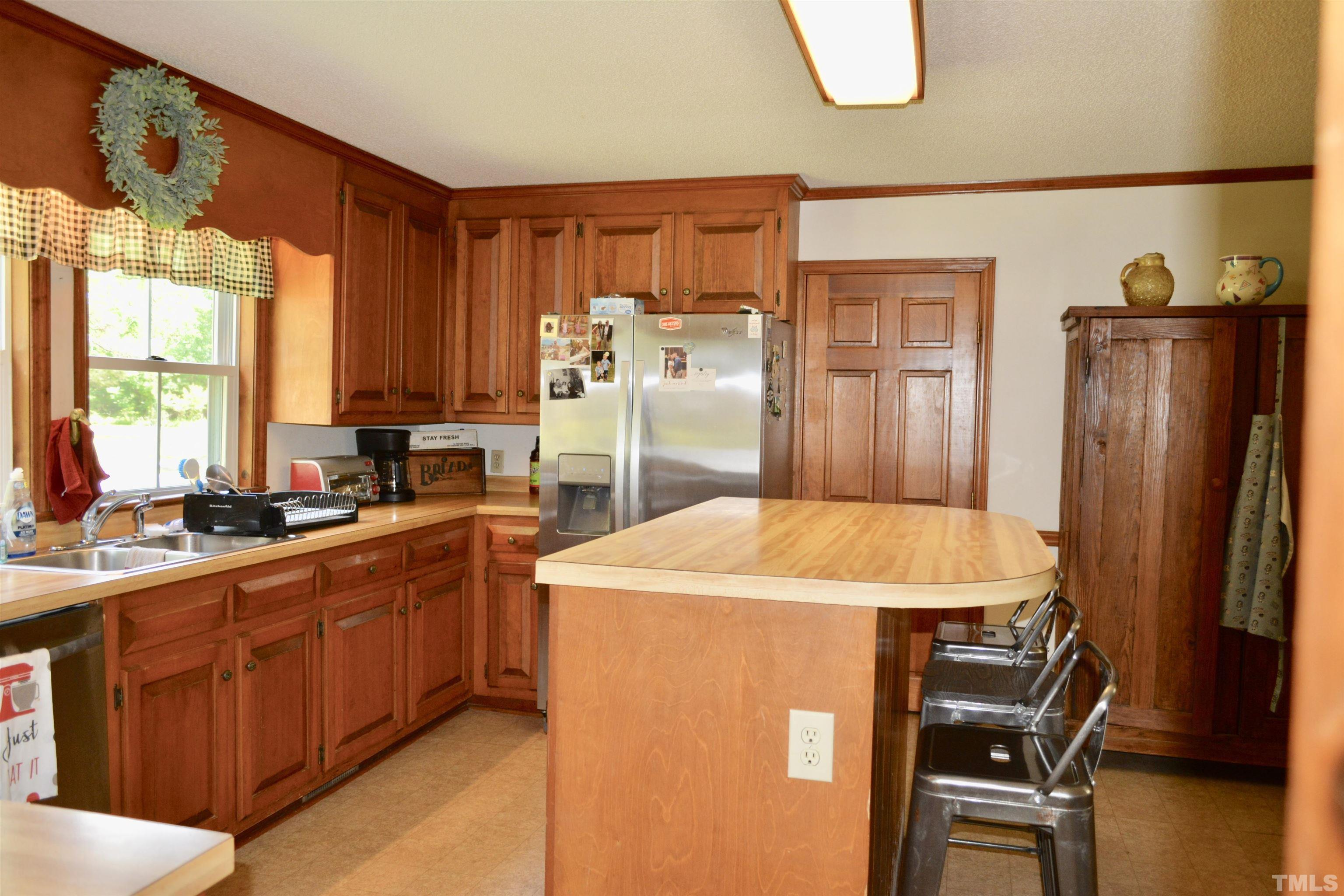 8837 Ransdell Road Raleigh, NC 27603 - Photo 4 of 48 a kitchen with stainless steel appliances kitchen island granite countertop a refrigerator a stove top oven a sink and dishwasher