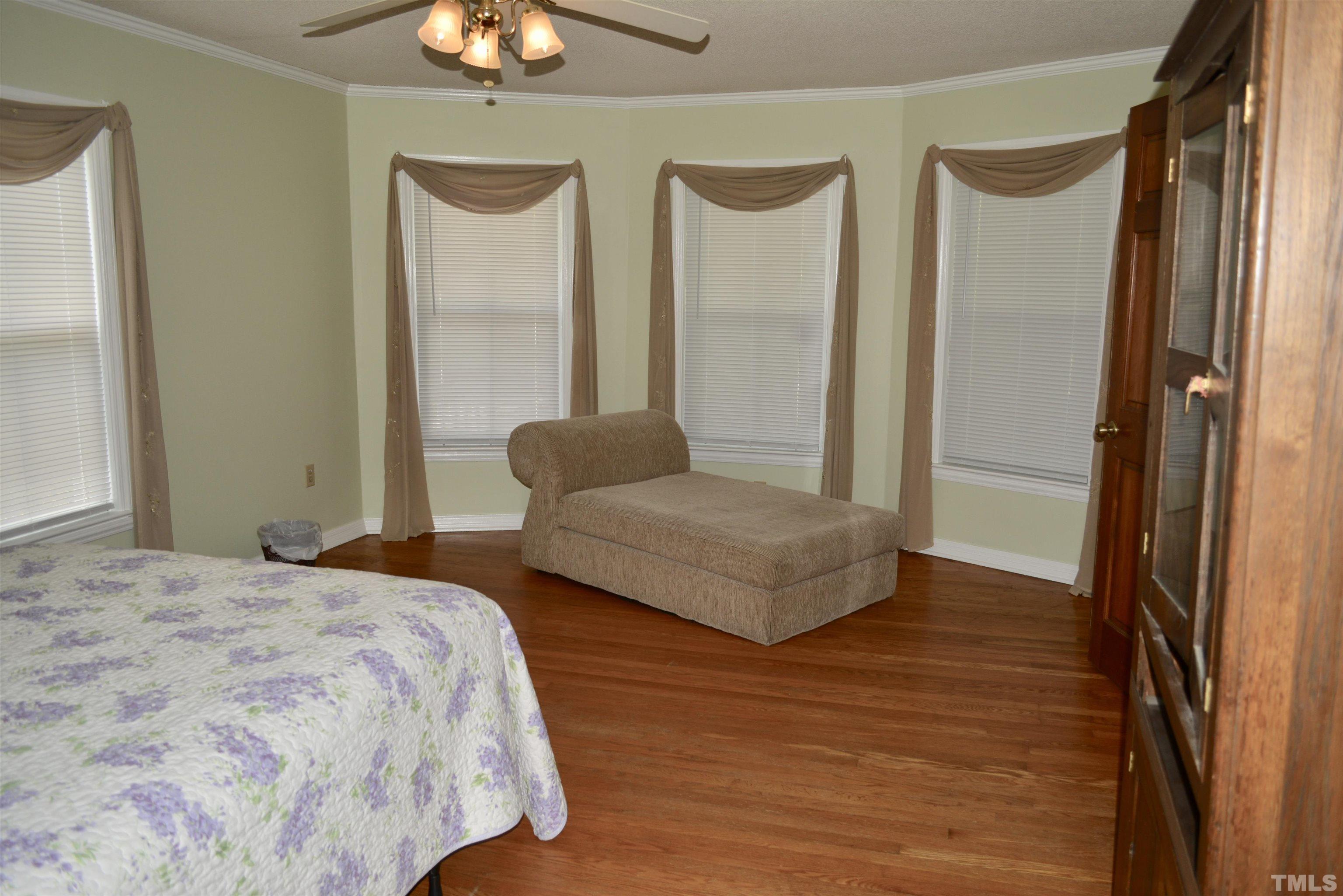 8837 Ransdell Road Raleigh, NC 27603 - Photo 9 of 48 a bedroom with a bed and a chandelier