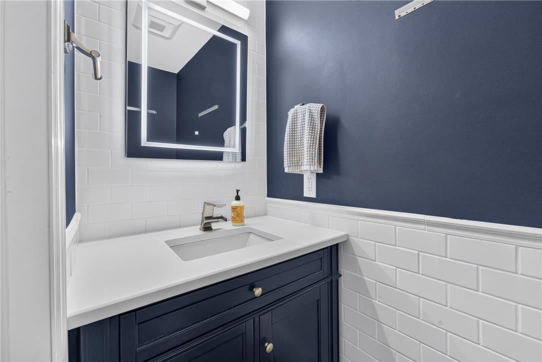 220 Pennbrook Road Stroudsburg, PA 18360 - Photo 22 of 60 A chic bathroom vanity features subway tile and an illuminated mirror, offering modern elegance.