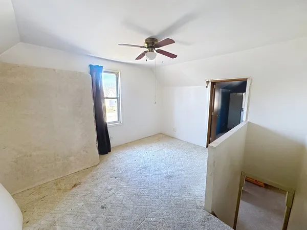 a view of a livingroom with a ceiling fan and window