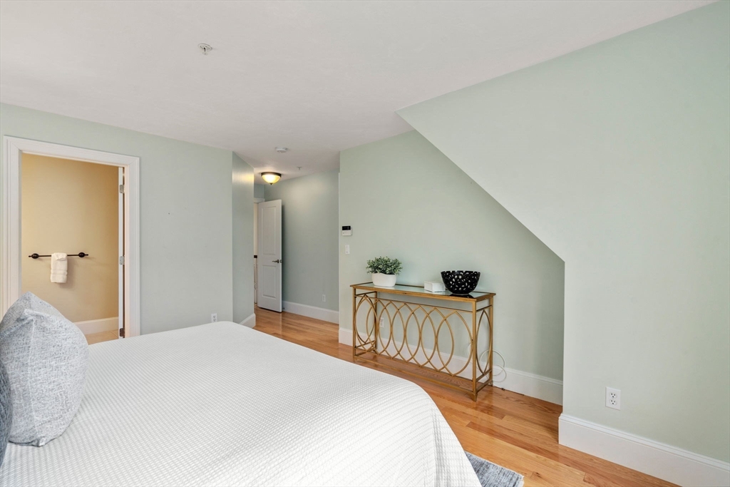 18 Maple Court, Unit 18 Needham, MA 02492 - Photo 16 of 25 a bedroom with a bed and a table in it