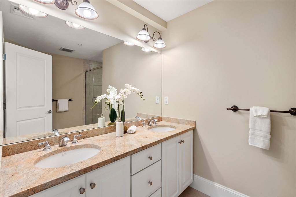 18 Maple Court, Unit 18 Needham, MA 02492 - Photo 17 of 25 a bathroom with a double vanity sink and a mirror