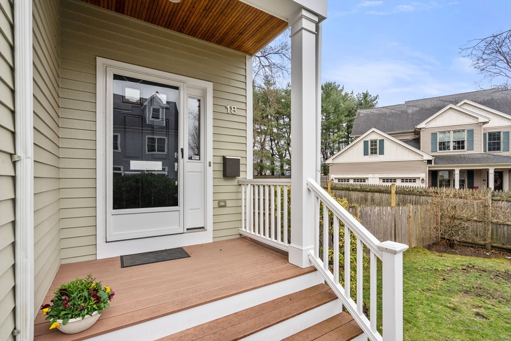 18 Maple Court, Unit 18 Needham, MA 02492 - Photo 2 of 25 a view of a house with a small yard and wooden floor and fence