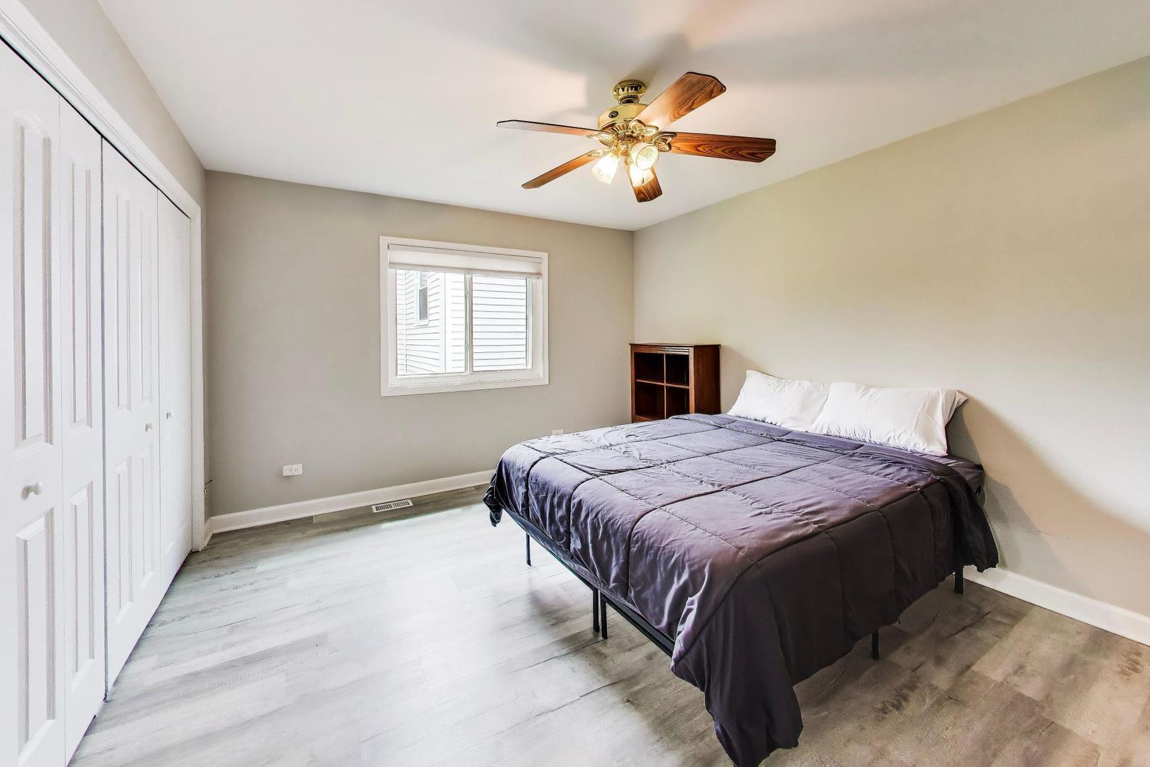 313 South Hi Lusi Avenue Mount Prospect, IL 60056 - Photo 19 of 40 a spacious bedroom with a bed and a chandelier