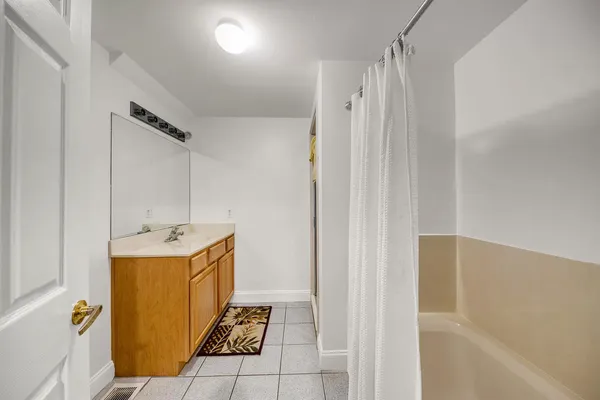 a bathroom with a sink and mirror with bathtub