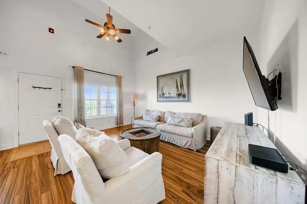 a living room with furniture a flat screen tv and a window